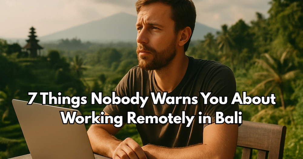 A serious-looking digital nomad works on his laptop with a Bali temple and volcano in the background, illustrating the challenges of working remotely in paradise