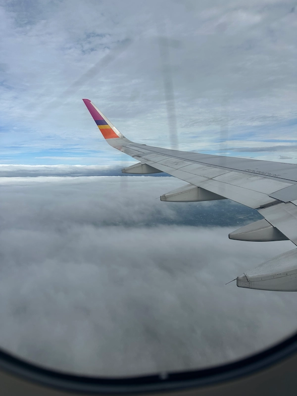 Clouds and wing plane by the window