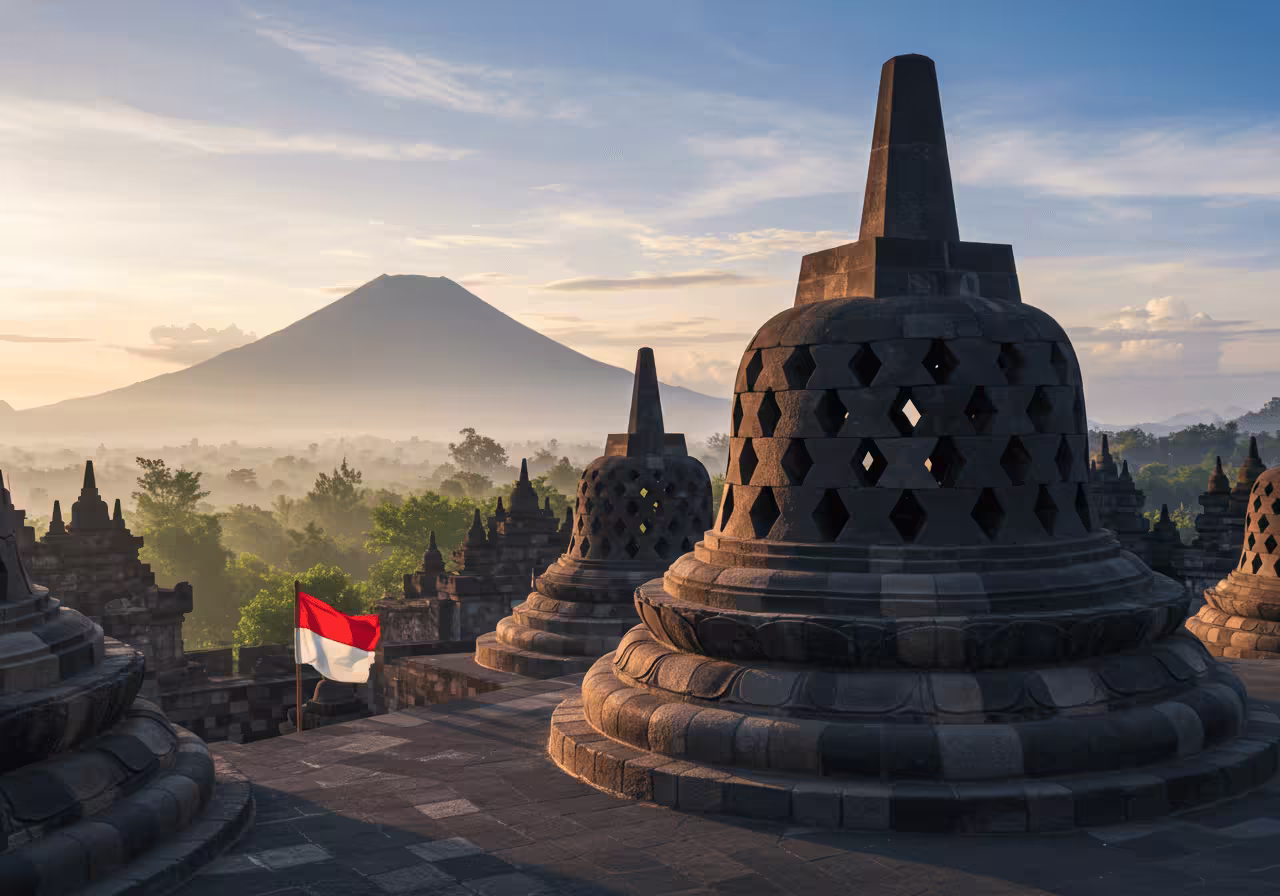 Better (More Descriptive & SEO-rich): Sunrise over the ancient Borobudur Temple stupas in Yogyakarta, Indonesia, with a volcano in the background, showcasing a low-cost digital nomad location.