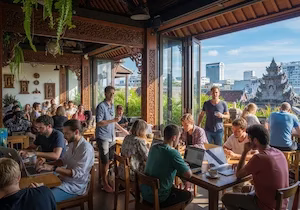 Digital nomads working on laptops in a busy, open-air coworking space in Bali, showing the potential for both productivity and distraction.