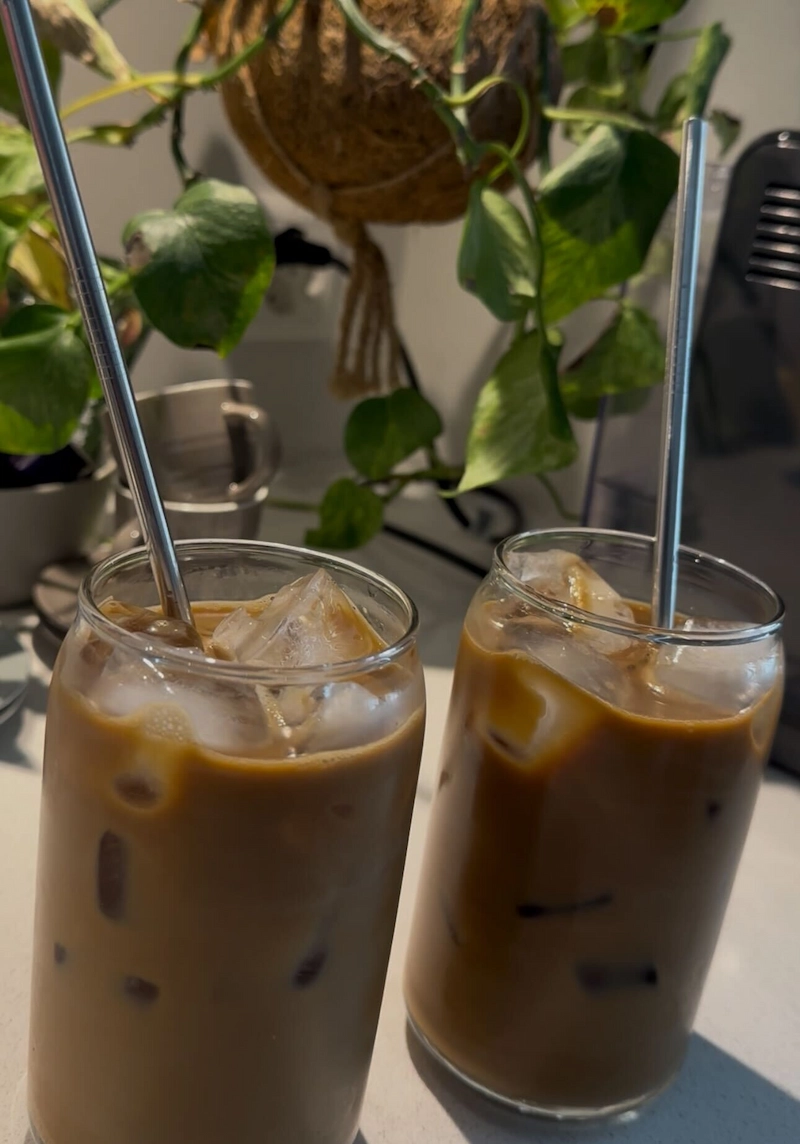 Two glasses of iced Vietnamese coffee made at home with metallic straws