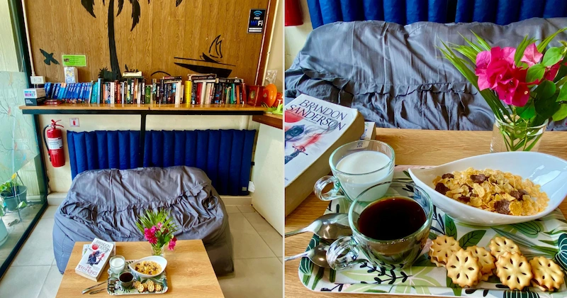The common area of Cocoon Hostel with guests eating breakfast at wooden tables.