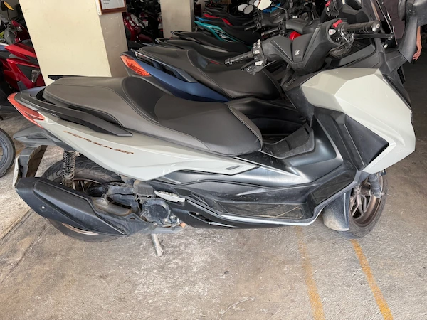 Picture of a grey Honda Forza 350 in a garage in Thailand.