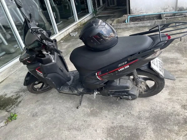 Picture of a black Yamaha GT 125 in front of a hotel in Thailand.
