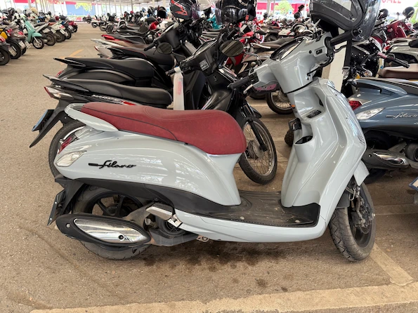 Picture of a grey Yamaha Grand Filano in a parking lot in Thailand.