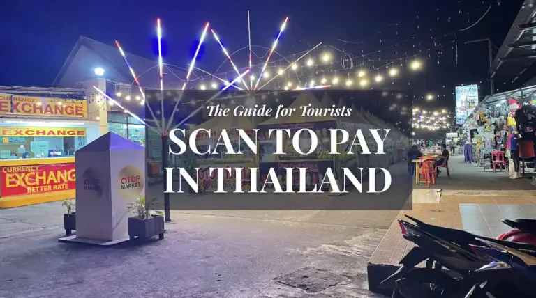 Night market scene in Thailand at evening with text overlay "The Guide for Tourists: Scan to Pay in Thailand," featuring street food stalls and currency exchange booths.