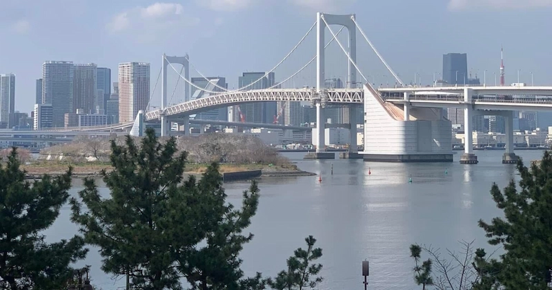 A daylight view of the Rainbow Bridge and Tokyo Bay from the Odaiba waterfront.