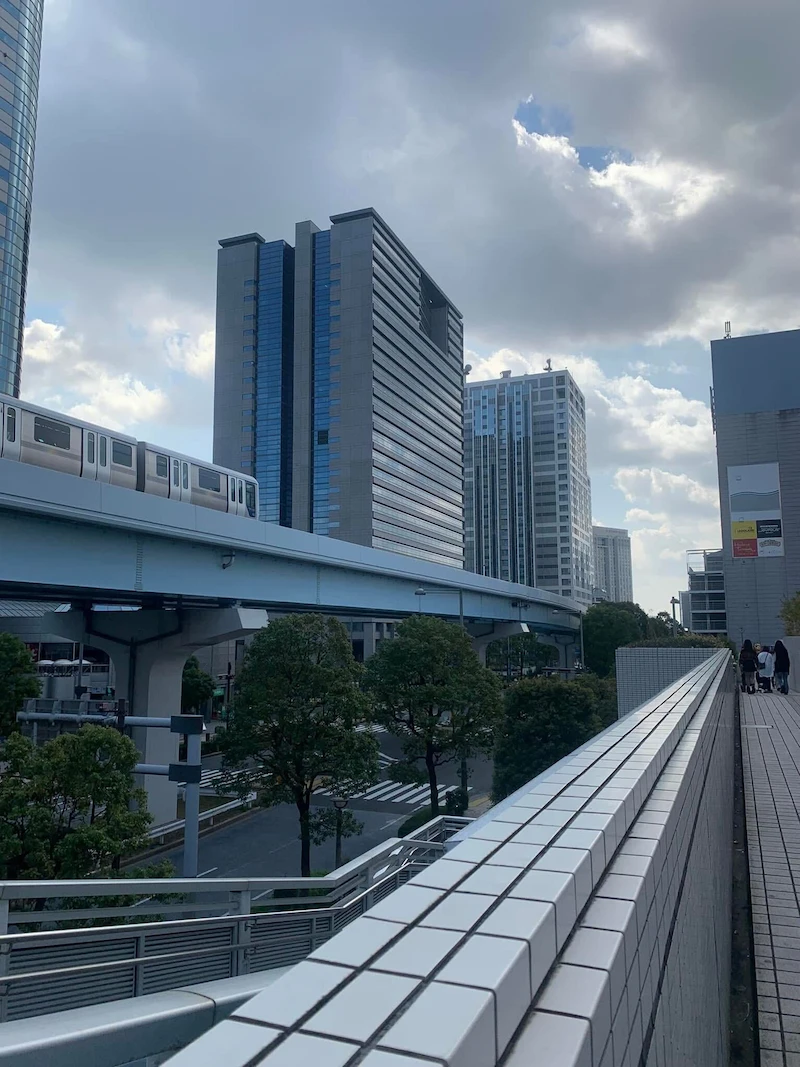 The elevated Yurikamome driverless train tracks passing through the modern buildings of Odaiba.