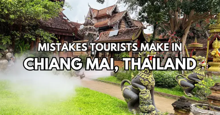A lush Chiang Mai temple entrance with stone lion statues and a text overlay: "Mistakes Tourists Make in Chiang Mai, Thailand."